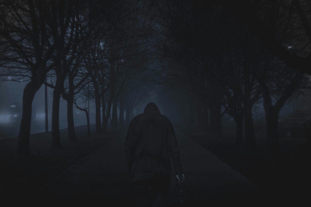 best psychological horror games showing dark atmospheric game scene with foggy corridor and unsettling character silhouette representing psychological horror genre