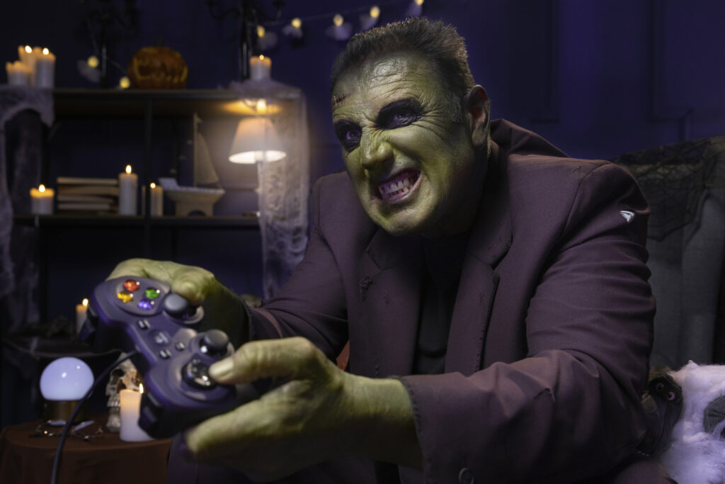 2 player horror games showing two players on a couch playing a co-op horror game together on a large screen with scary game imagery representing the best 2 player horror games for PS5 Xbox and PC