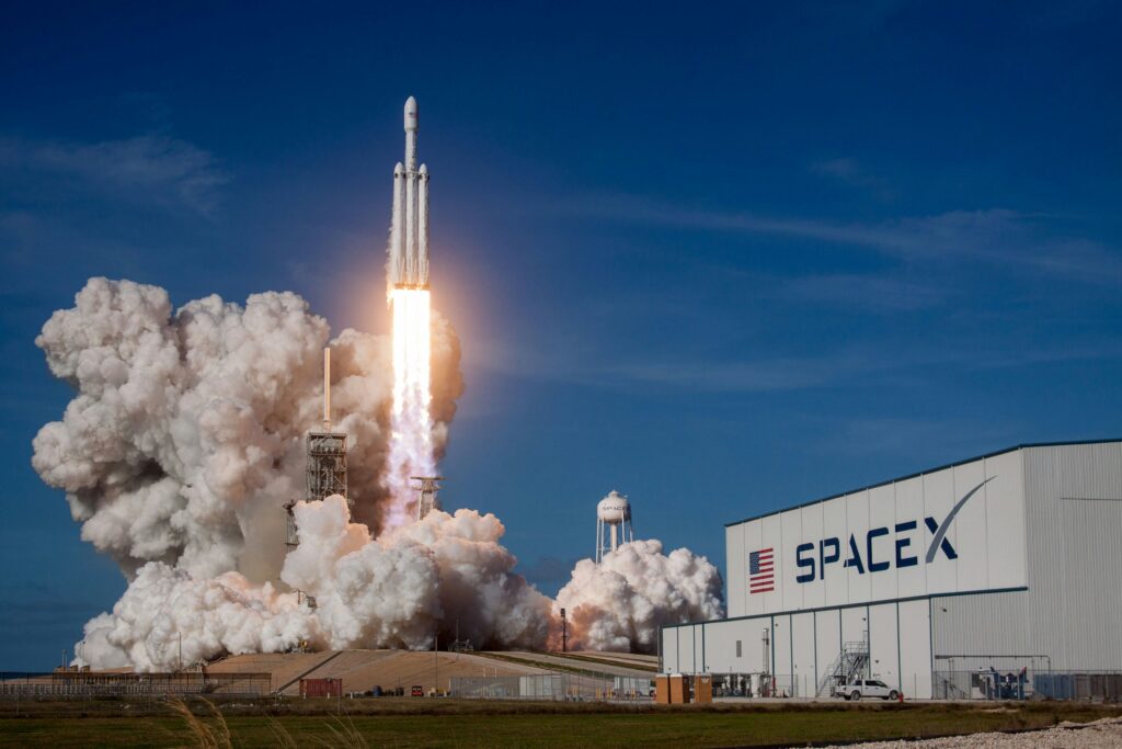 spacex store merchandise showing spacex branded apparel and accessories including a t-shirt cap and mission patch representing official spacex merchandise