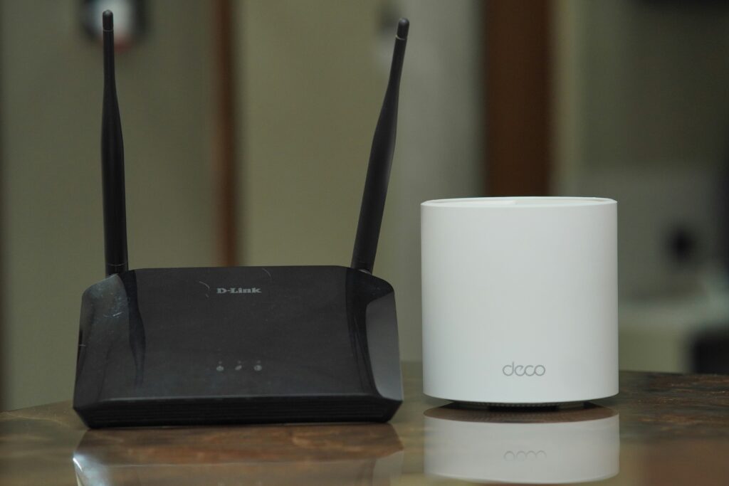 modem vs router comparison showing a cable modem on the left connected by ethernet cable to a wireless router on the right representing the difference between a modem and router in a home network setup